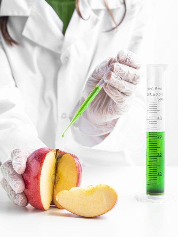 person-injecting-apple-with-green-chemicals person-injecting-apple-with-green-chemicals
